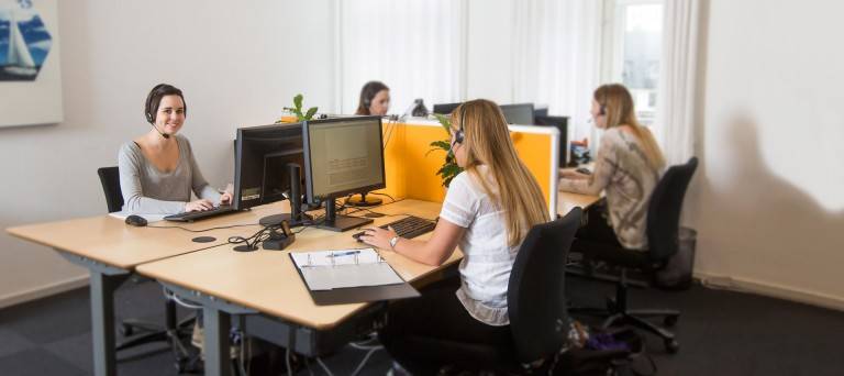 Call management medarbejdere sidder i kontor omgivelser